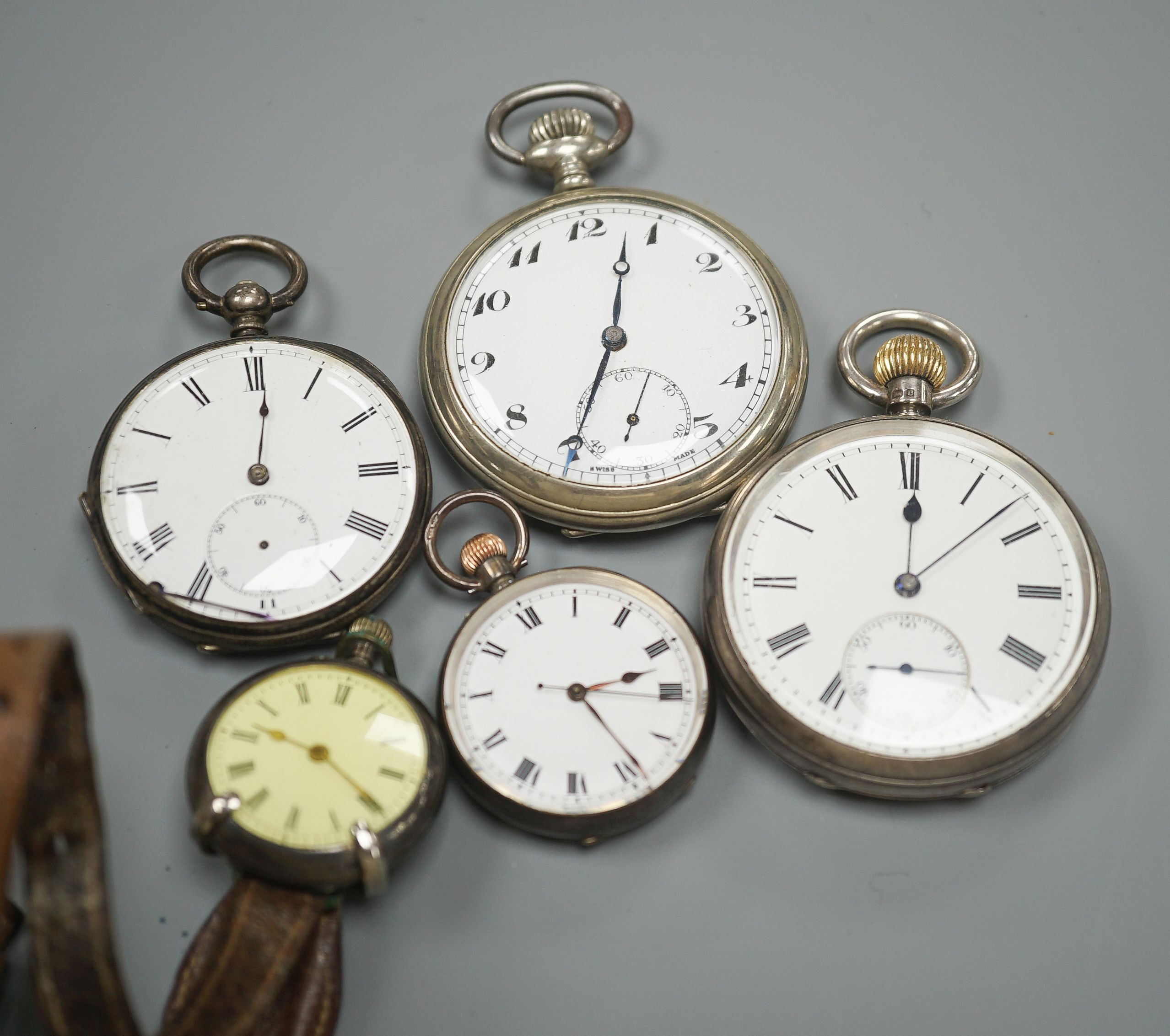 An early 20th century silver open face pocket watch, two white metal fob watches, a white metal wrist watch and one other pocket watch.